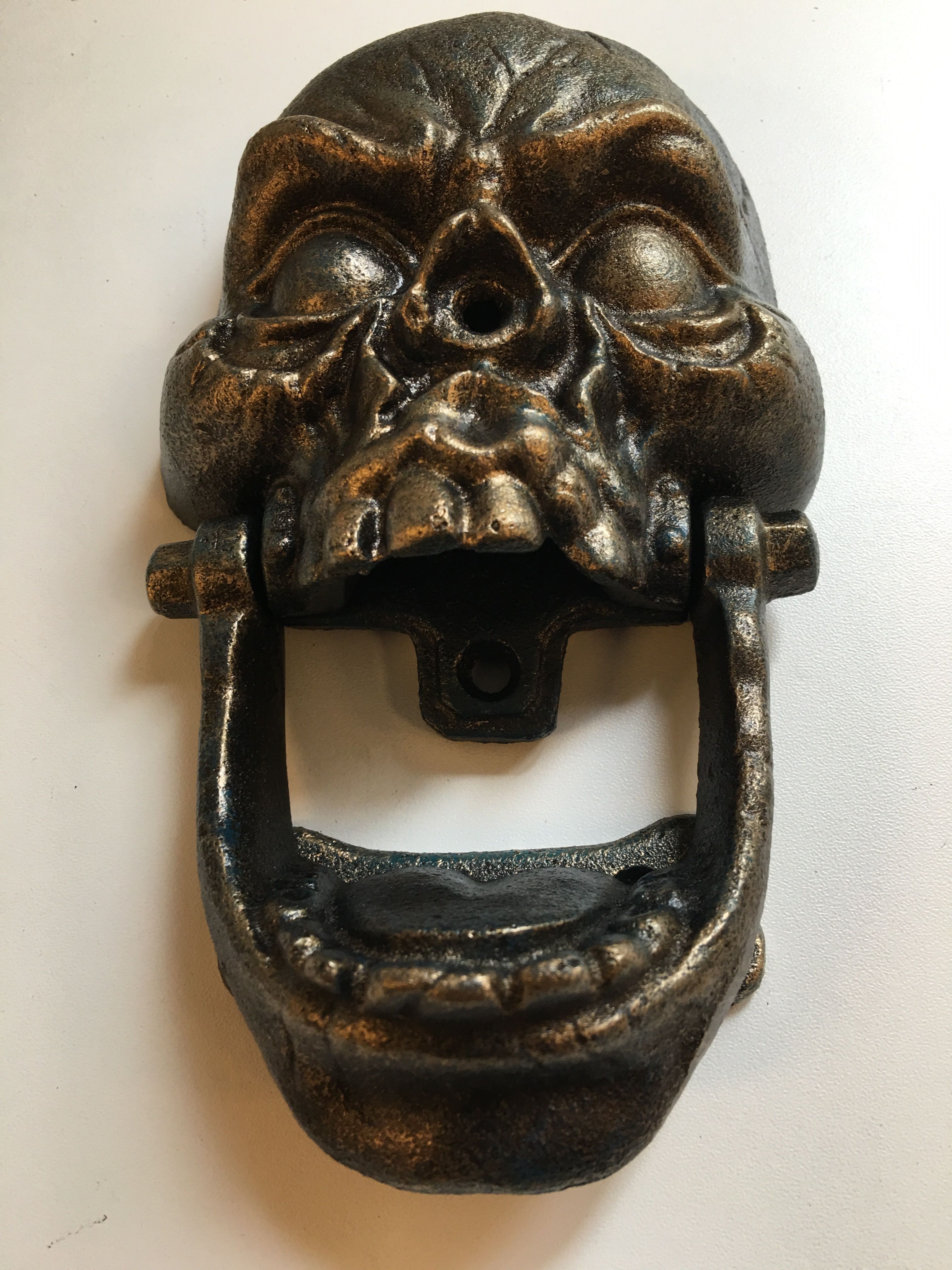 Gietijzeren bronskleurige schedel als deurklopper.