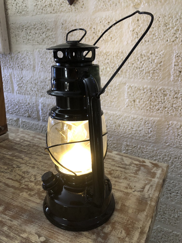 Een antiek uitziende olie-storm-lamp metaal zwart met led verlichting.