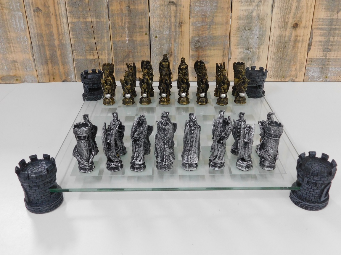 Een schaakspel met als thema: ' ridder-draken', fraaie schaakstukken als middeleeuws e ridders op glazen schaakbord met torens.