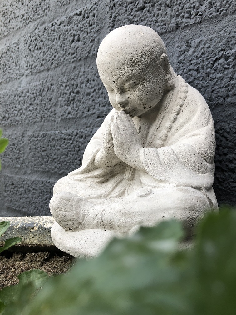Shaolin-Mönch sitzend betend, voller Stein