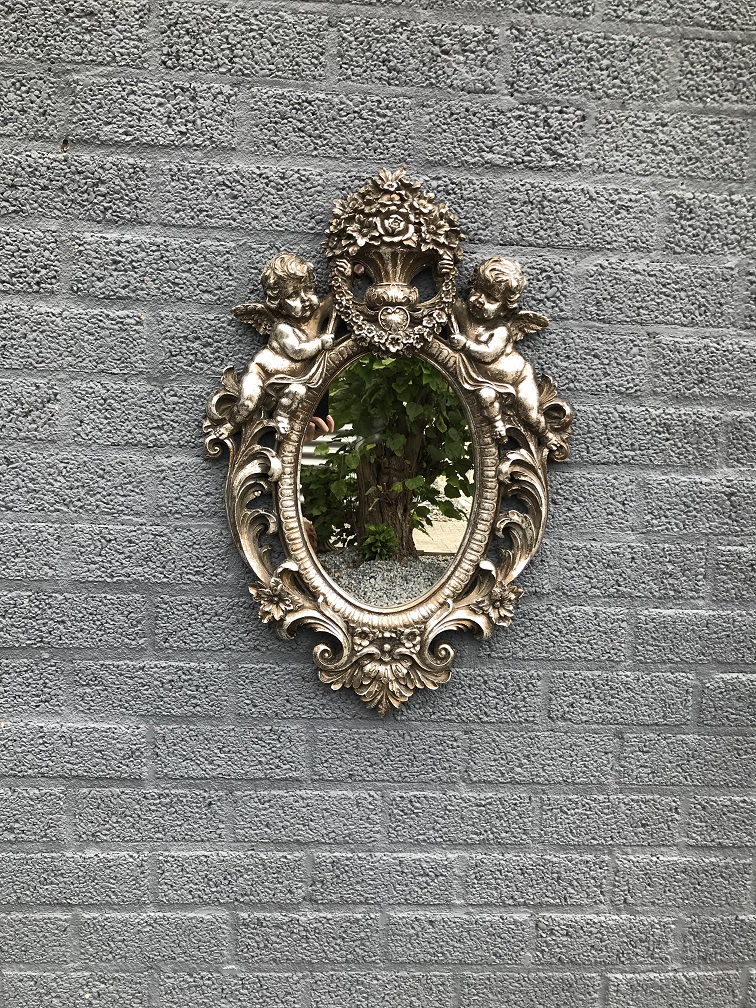 Een mooie decoratieve spiegel, zilveren omlijsting met krans gedragen door 2 engelen