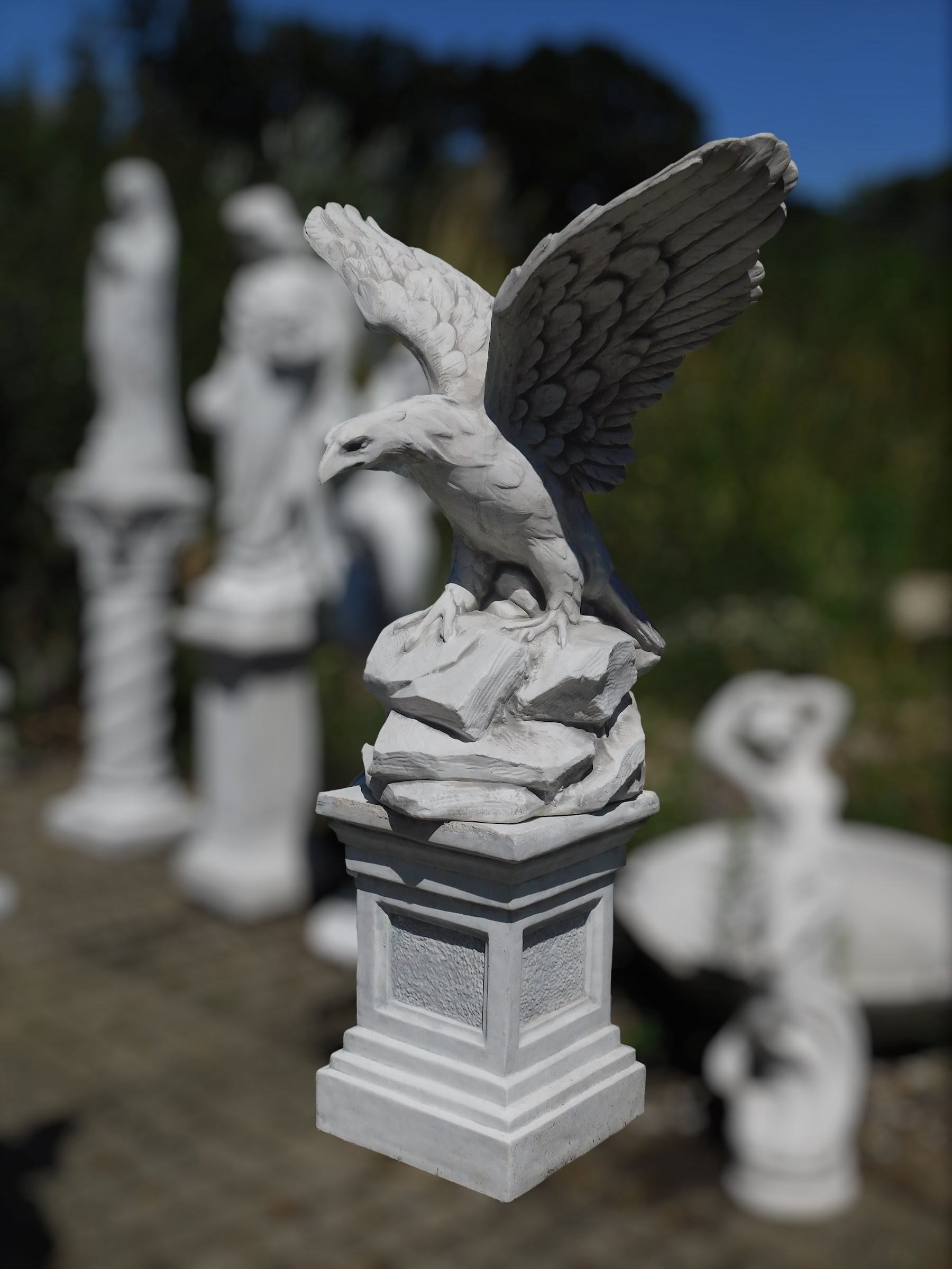 Sculpture de aigle avec les ailes deployées Perché sur un tronc