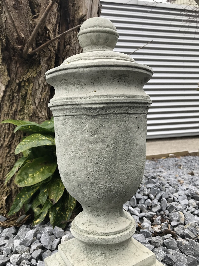 Een stenen urn, grafdecoratie in een grijze kleur