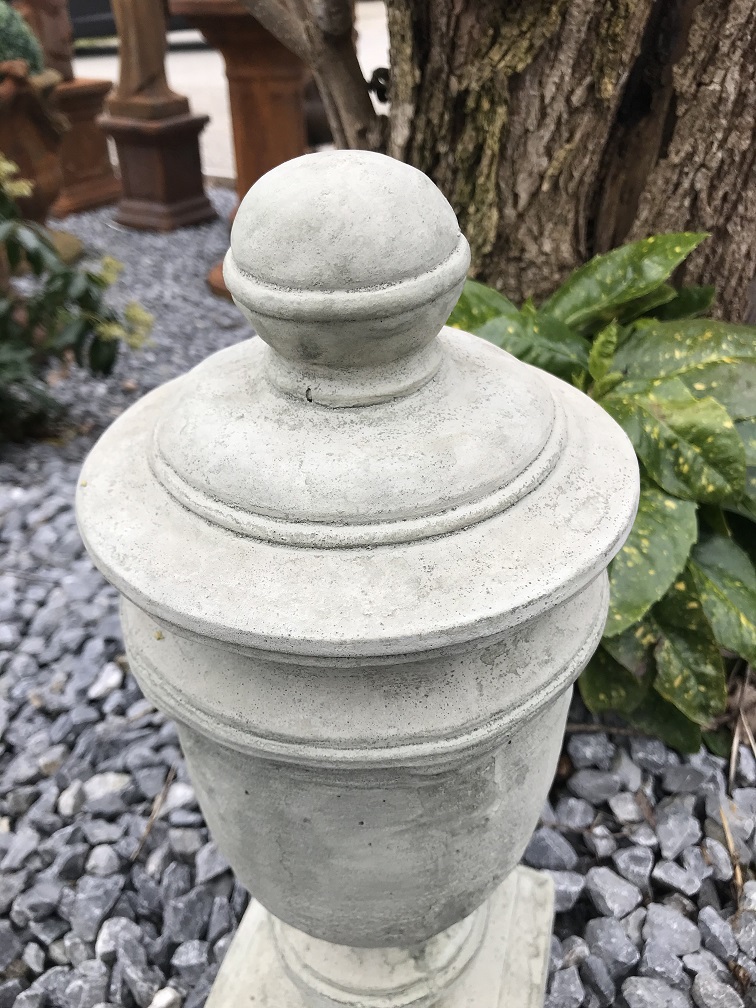 Een stenen urn, grafdecoratie in een grijze kleur