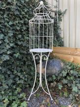 Grande cage à oiseaux reposant sur des pieds en fer forgé