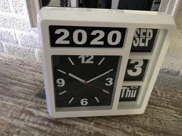Eine Uhr mit Jahr, Datum und Uhrzeit, mit Ständer, kann aber auch an die Wand gehängt werden, weiß
