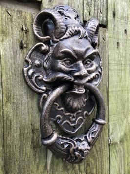 Gietijzeren bronskleurige deurklopper met hoofd van de duivel.