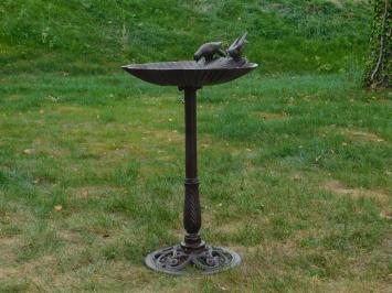 Fors vogel bad, om de vogeltjes van eten en drinken te voorzien, vol gietijzer, bruin